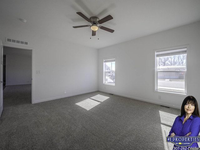 carpeted empty room featuring visible vents, ceiling fan, and baseboards