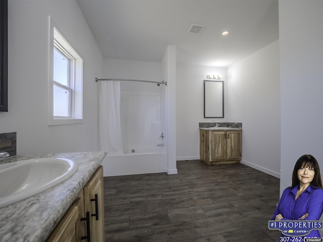 bathroom with visible vents, wood finished floors, a sink, shower / bathtub combination with curtain, and two vanities