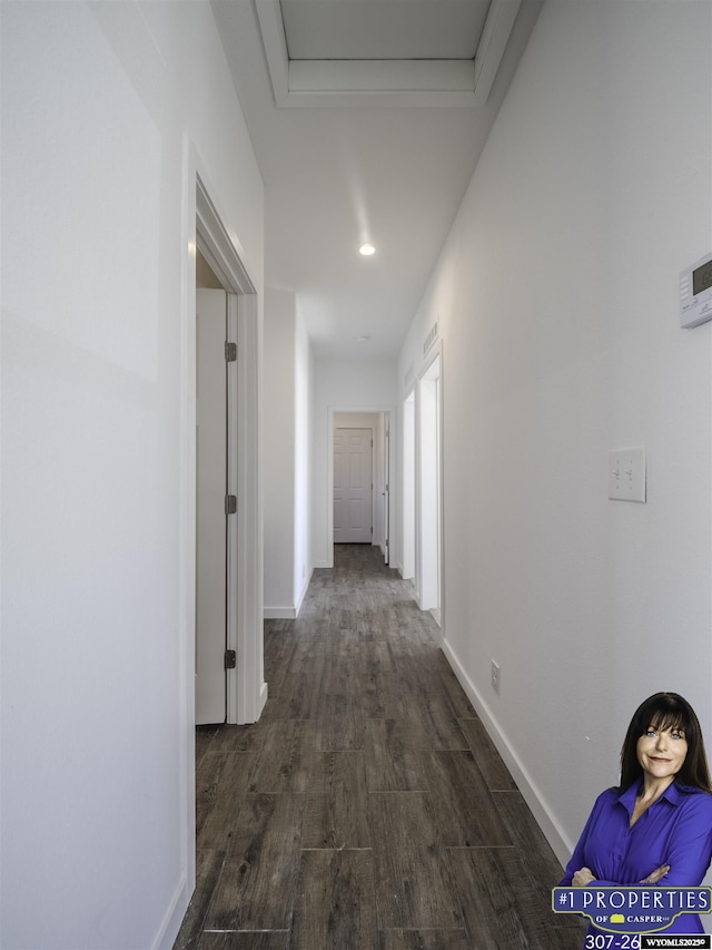 hallway featuring dark wood-type flooring, recessed lighting, and baseboards