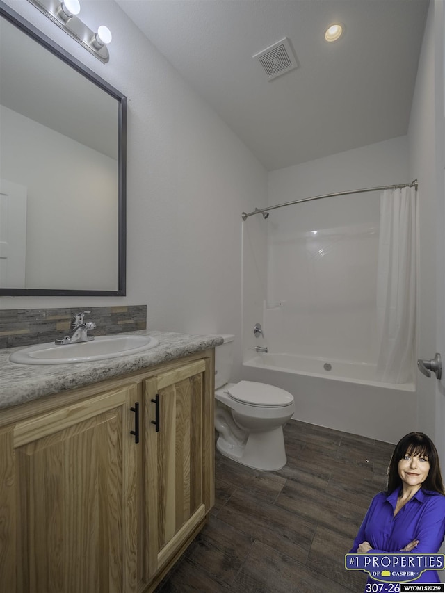 full bath featuring toilet, wood finished floors, vanity, visible vents, and shower / bathtub combination with curtain