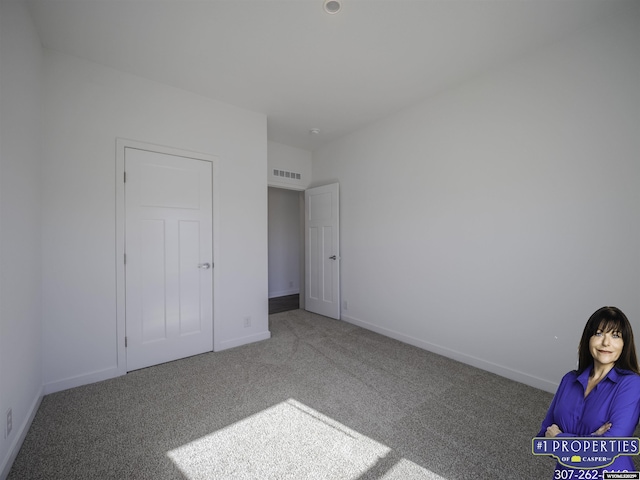 unfurnished bedroom with carpet flooring, visible vents, and baseboards