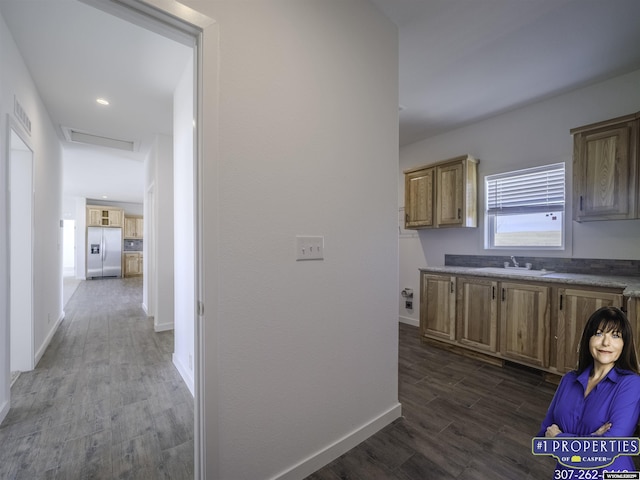 hall featuring dark wood-style floors, visible vents, attic access, a sink, and baseboards