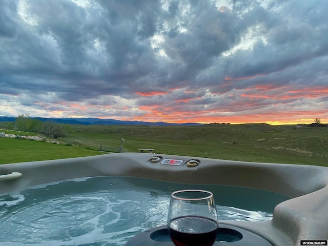 pool at dusk featuring a mountain view