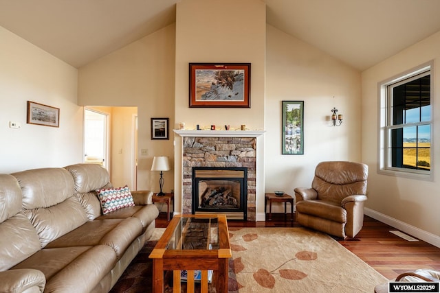 living room featuring high vaulted ceiling, a fireplace, baseboards, and wood finished floors