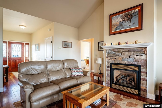 living room with a fireplace, vaulted ceiling, baseboards, and hardwood / wood-style flooring