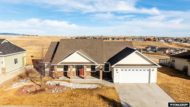 view of front facade with a garage, concrete driveway, roof with shingles, and stone siding