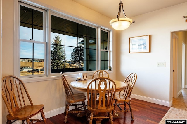 dining space with dark wood-style floors and baseboards