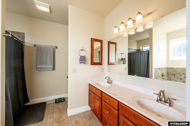 full bathroom with double vanity, tile patterned flooring, baseboards, and a sink