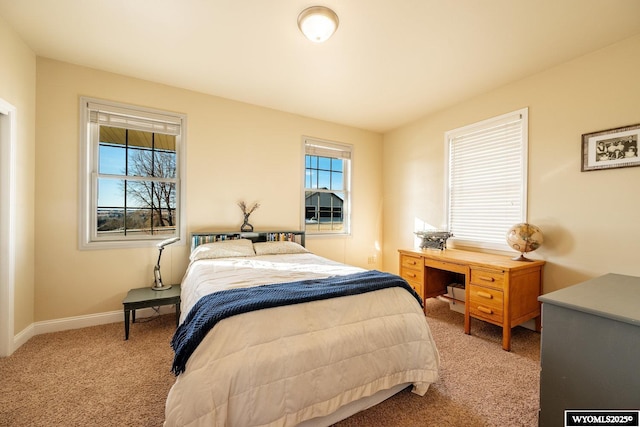 bedroom featuring baseboards and light colored carpet