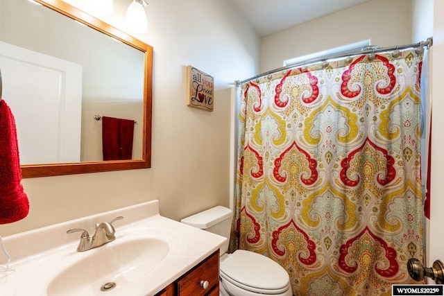 bathroom with a shower with shower curtain, vanity, and toilet