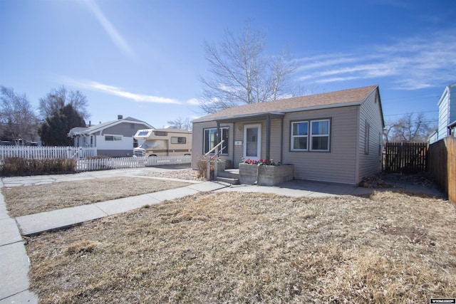 bungalow-style house featuring covered porch and fence private yard