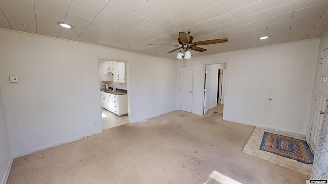 empty room with a ceiling fan and baseboards