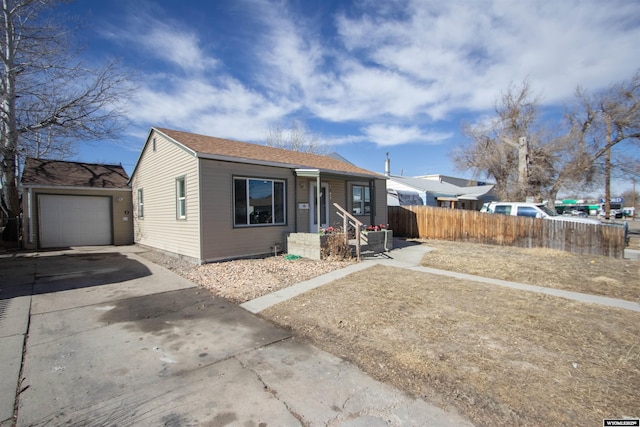 bungalow-style home with concrete driveway and fence