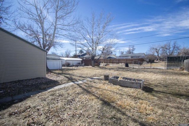 view of yard with fence and an outbuilding