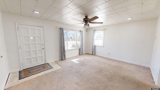 foyer with carpet flooring, ceiling fan, and baseboards