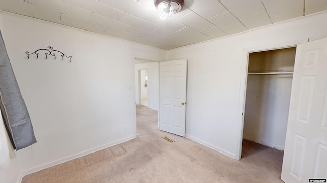 unfurnished bedroom with a closet, carpet flooring, and baseboards