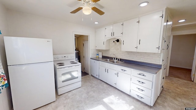 kitchen with white appliances, a sink, white cabinets, decorative backsplash, and dark countertops