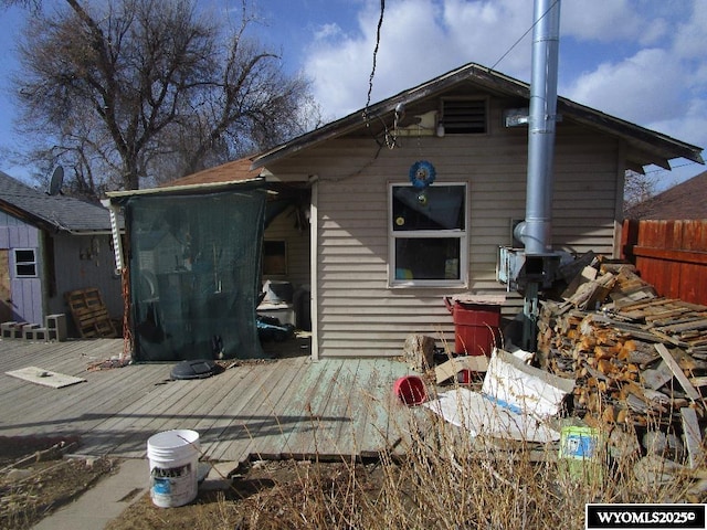 back of house featuring fence and a deck