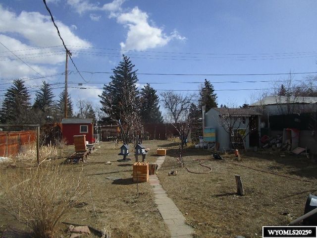 view of yard with a fenced backyard, a storage unit, and an outdoor structure