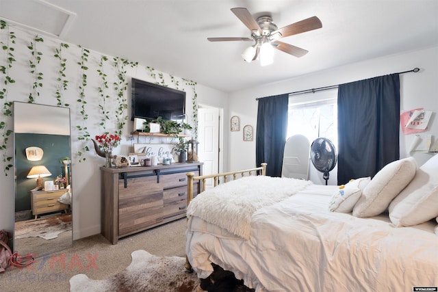 bedroom featuring a ceiling fan, attic access, and light carpet