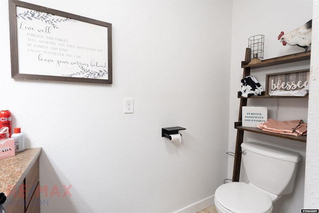 bathroom with baseboards and toilet