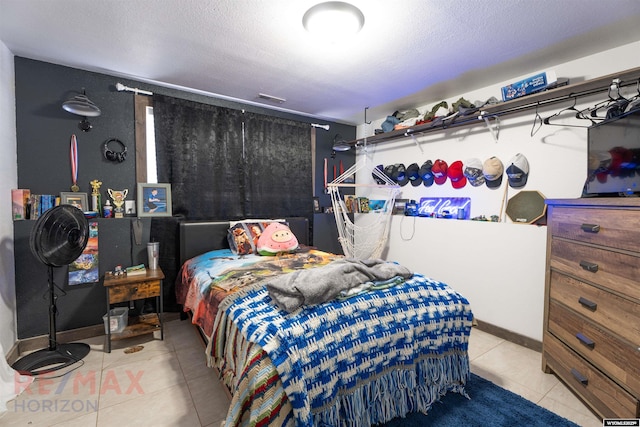 bedroom featuring light tile patterned floors, visible vents, and a textured ceiling