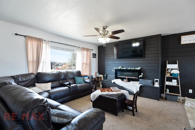 living room with a large fireplace, light carpet, and a ceiling fan