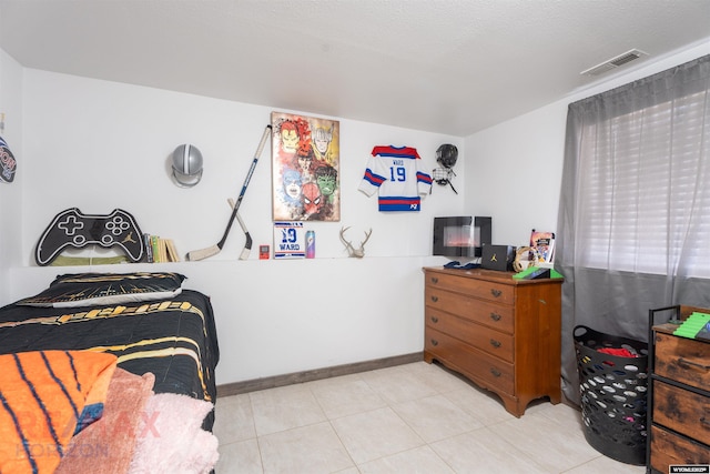 bedroom with light tile patterned floors, visible vents, and baseboards