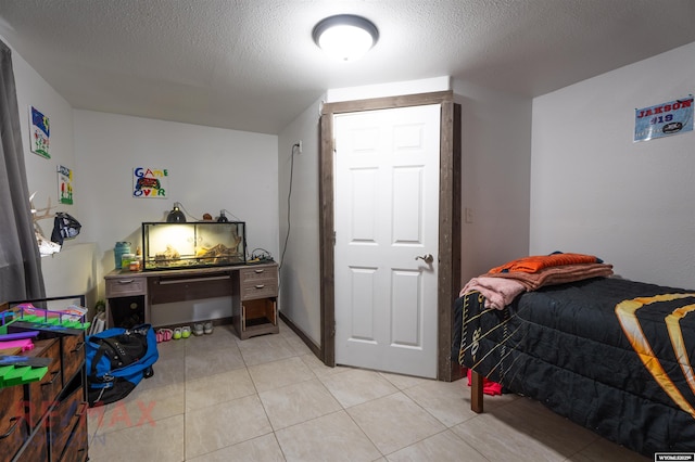 bedroom with light tile patterned flooring and a textured ceiling