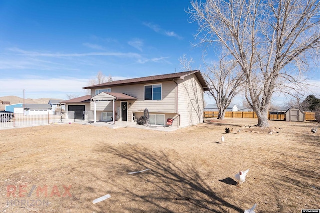 view of front of property with a fenced backyard, an outdoor structure, and a storage shed