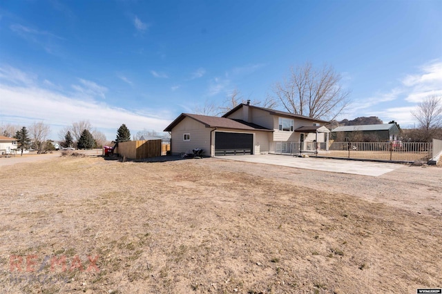 view of side of home featuring driveway and fence