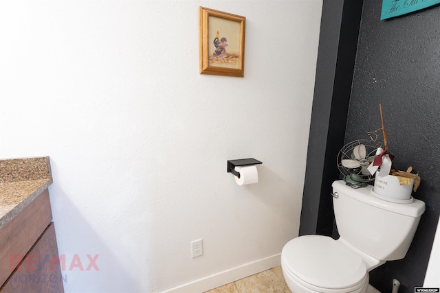 bathroom featuring tile patterned flooring, baseboards, vanity, and toilet