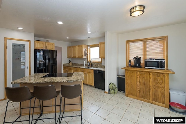 kitchen with light tile patterned floors, a kitchen island, a sink, a kitchen breakfast bar, and black appliances