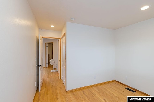 corridor featuring light wood-style flooring, recessed lighting, visible vents, and baseboards