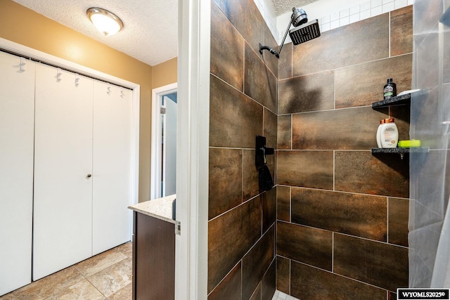 interior space with a textured ceiling and a tile shower