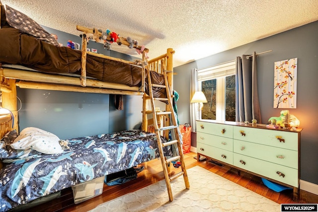 bedroom featuring a textured ceiling and wood finished floors