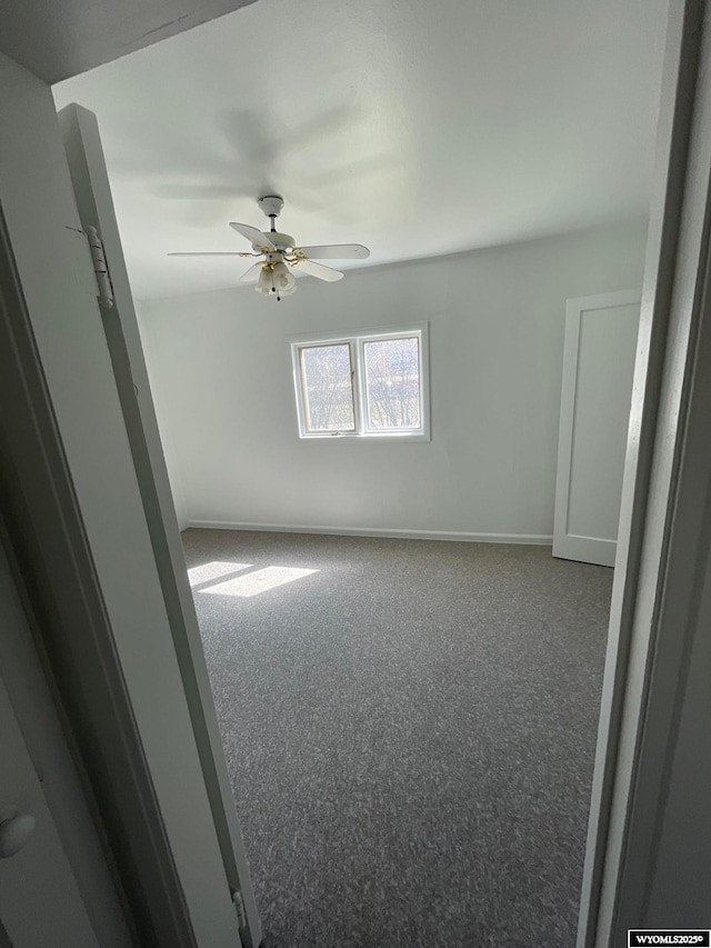 unfurnished room with ceiling fan and baseboards