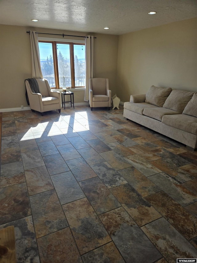 living room with recessed lighting, a textured ceiling, and baseboards
