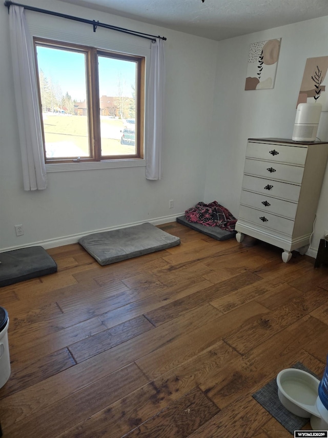 bedroom featuring dark wood finished floors and baseboards