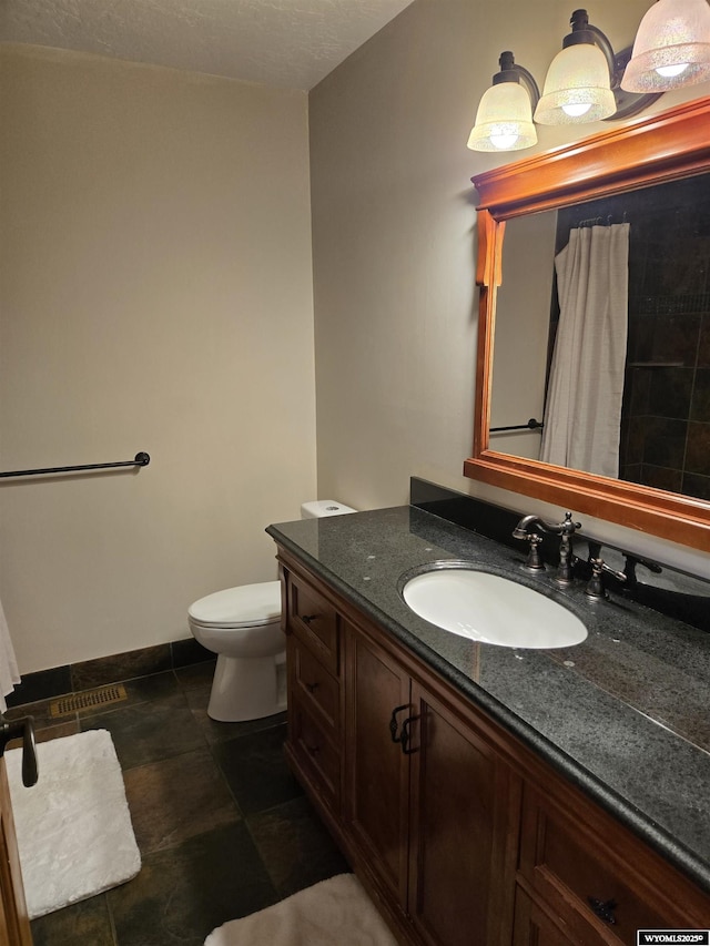 bathroom with vanity, toilet, and baseboards