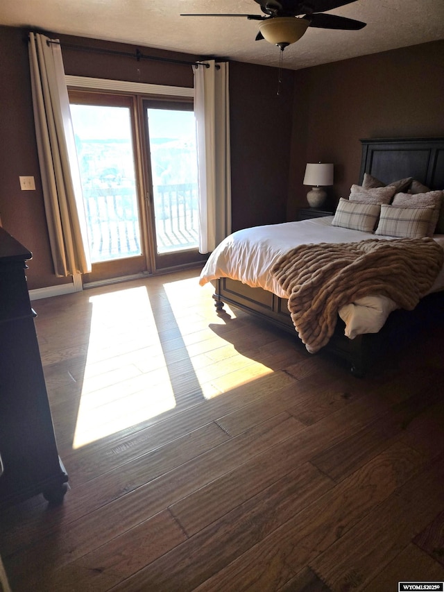 bedroom with access to exterior, dark wood finished floors, and a ceiling fan