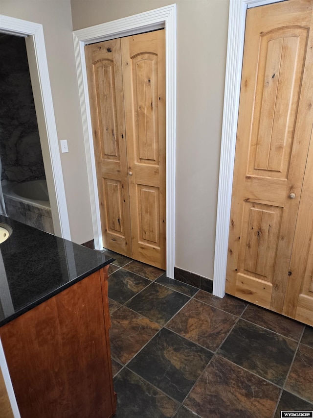 foyer with baseboards and stone tile floors