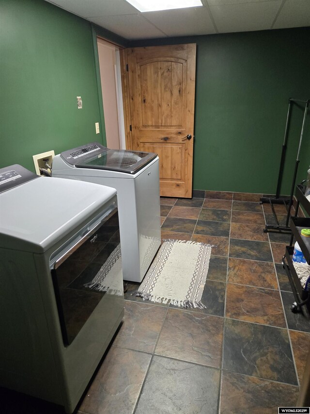laundry area with laundry area, stone finish flooring, and separate washer and dryer