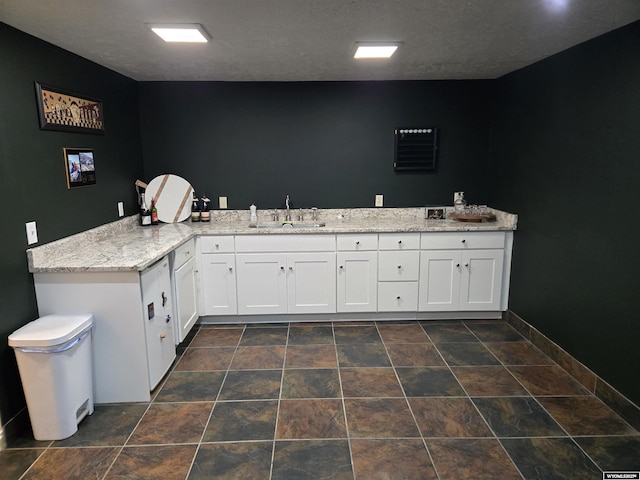 bathroom featuring a sink and baseboards