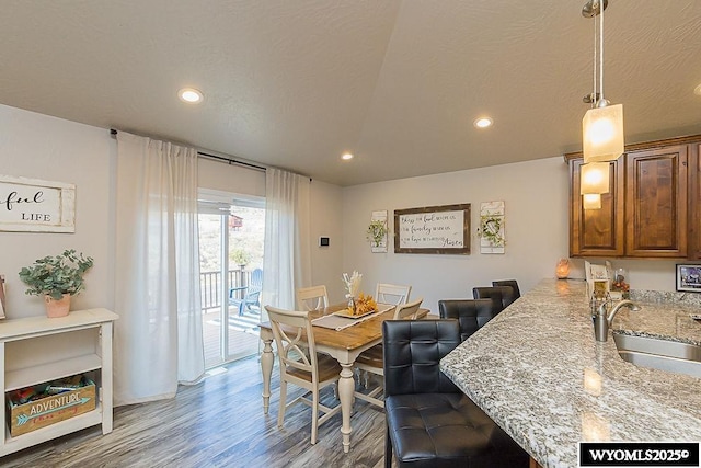 dining room with a textured ceiling, wood finished floors, and recessed lighting