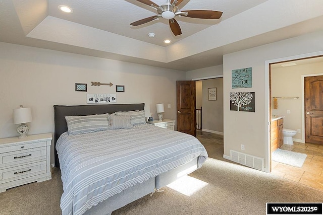 bedroom featuring visible vents, a tray ceiling, baseboards, and recessed lighting