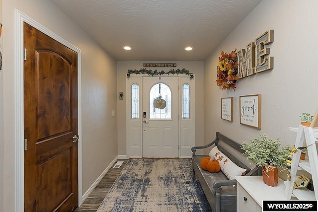 entrance foyer with baseboards, dark wood finished floors, a textured ceiling, and recessed lighting