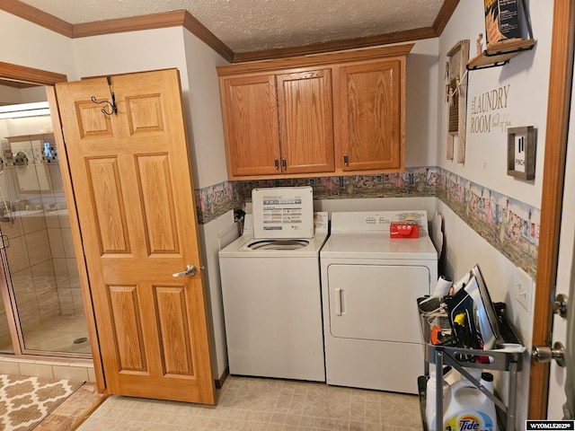 washroom featuring cabinet space, ornamental molding, separate washer and dryer, and a textured ceiling