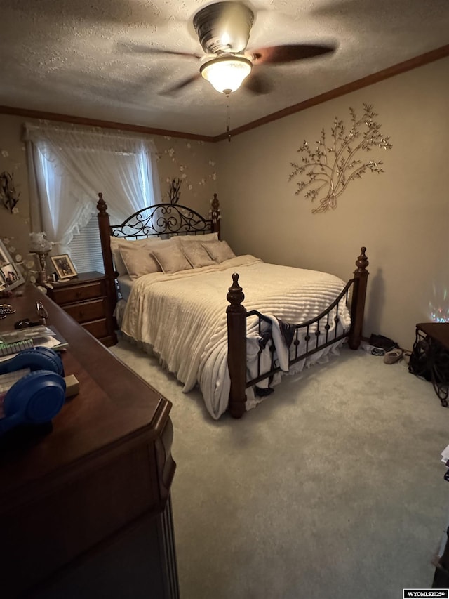 carpeted bedroom featuring ceiling fan, a textured ceiling, and crown molding