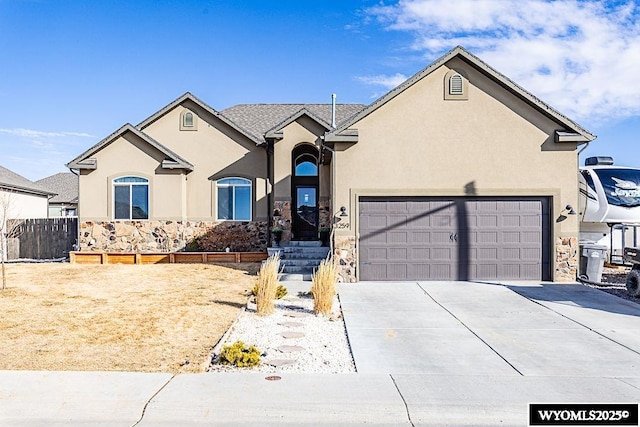 view of front of house with a garage, concrete driveway, fence, and stucco siding